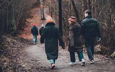 Tre personer som promenerar ute i skogen